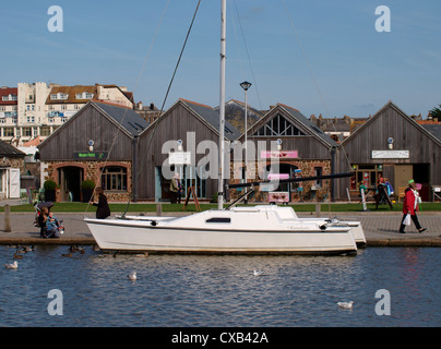 Yacht auf der Bude Kanal vor Geschäften, Bude, Cornwall, UK Stockfoto