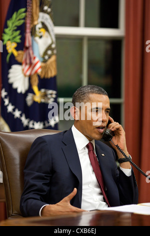 Präsident Barack Obama spricht am Telefon 1. Mai 2011 im Oval Office vor Abgabe einer Erklärung über die Mission gegen Osama bin Laden für die Medien. Der Präsident machte eine Reihe von aufrufen, einschließlich Präsidenten George W. Bush und Bill Clinton und andere, um sie von der erfolgreichen Mission zu informieren. Stockfoto