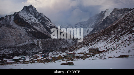 Schneebedeckte Berge und eine gefrorene Gletscher hinter dem Dorf Kyanjin Gompa, Langtang-Tal, Nepal Stockfoto