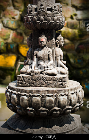 Buddha Skulptur in tibetischen Kloster über Gebet Steinen Hintergrund. Nepal, Kathmandu Stockfoto