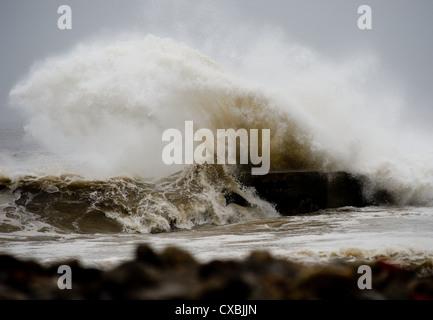 Wellen über Felsen in einem Gebiet, bekannt als South Gare in Teesside in England als schwere See lash die Küste. Stockfoto