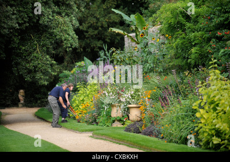 Ein Gärtner mit Einfassung Scheren arbeiten entlang eines Pfades Worcester College in Oxford Stockfoto