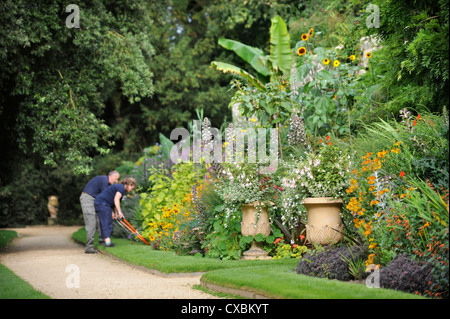 Ein Gärtner mit Einfassung Scheren arbeiten entlang eines Pfades Worcester College in Oxford Stockfoto