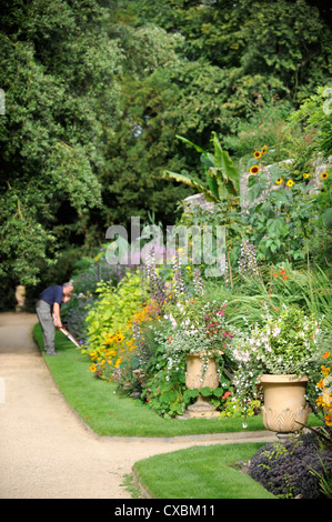 Ein Gärtner mit Einfassung Scheren arbeiten entlang eines Pfades Worcester College in Oxford Stockfoto