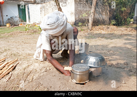 Bihari Mann in weißen Turban und Dhoti, so dass Lehmofen in den Boden, um seine kocht bei Sonepur Vieh Fair, Bihar, Indien, Asien Stockfoto