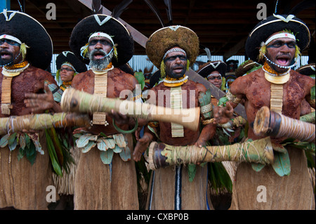 Bunt gekleidet und Gesicht gemalt lokalen Stämme feiert die traditionelle Sing Sing im Hochland von Papua-Neuguinea Stockfoto