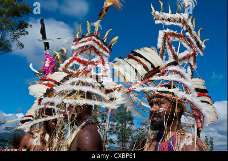 Bunt gekleidet und Gesicht gemalt lokalen Stämme feiert die traditionelle Sing Sing im Hochland von Papua-Neuguinea Stockfoto