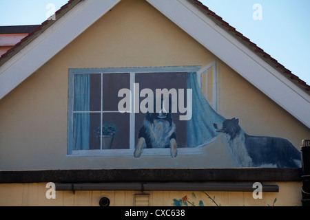 Malte Hunde Blick aus Fenster auf Seite der Bungalow in Swanage Stockfoto