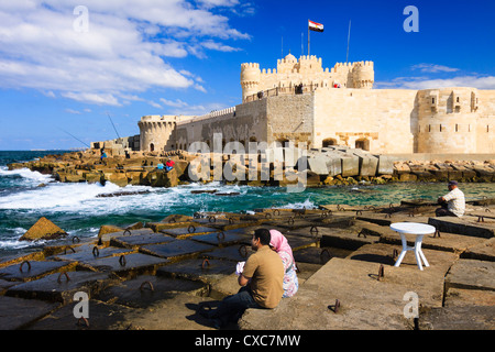 Paar mit Baby durch die Wellenbrecher vor Qaitbey Fort, Alexandria, Ägypten Stockfoto