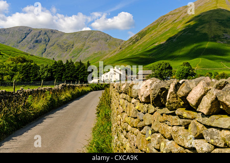 Eine schmale Gasse, gesäumt von Trockensteinmauern führt zu dem Wasdale Head Inn eingebettet in tiefste Tal am Fuße des majestätischen Gipfeln Stockfoto