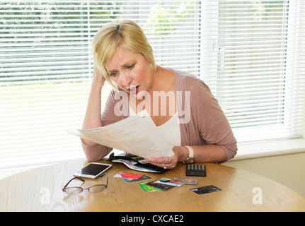 Frau schockiert über ihre Kreditkartenabrechnung lesen Stockfoto