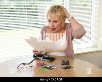 Frau schockiert über ihre Kreditkartenabrechnung lesen Stockfoto