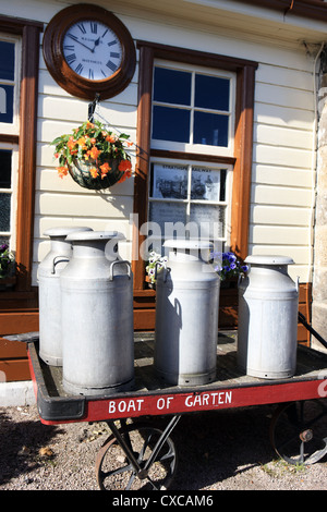 Milchkannen auf einem Wagen an der restaurierten Boat of Garten Steam Railway Station in den schottischen Highlands Stockfoto