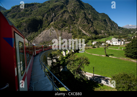 Schweiz. Bernina-Express durch und über die kreisförmige Brusio Viadukt. 9-12. Stockfoto
