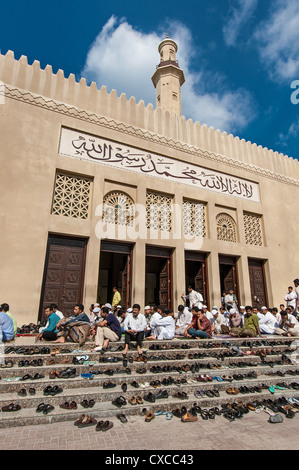 Eine Reihe von unbekannten Männern warten außerhalb der Moschee für das Mittagsgebet am 31. Dezember 2004 in Dubai, VAE. Stockfoto