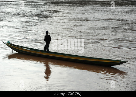 Silhouette der Mann steht im Kanu auf dem Mekong Fluss, Luang Prabang. Stockfoto