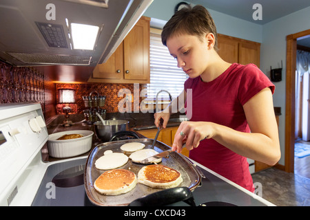 Weibliche Teenager Pfannkuchen zum Frühstück in ihrer Küche zubereiten. Stockfoto