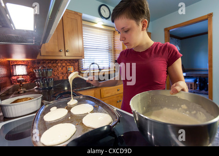 Weibliche Teenager Pfannkuchen zum Frühstück in ihrer Küche zubereiten. Stockfoto