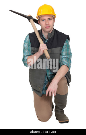 Mann mit Pick-Ax kniete auf einem Knie Stockfoto