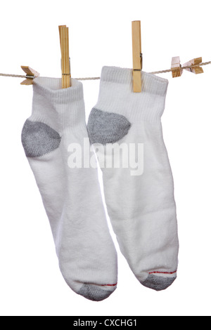 Frische saubere weiße Baumwollsocken aufhängen und trocknen auf der Wäscheleine auf weißem Hintergrund. Stockfoto