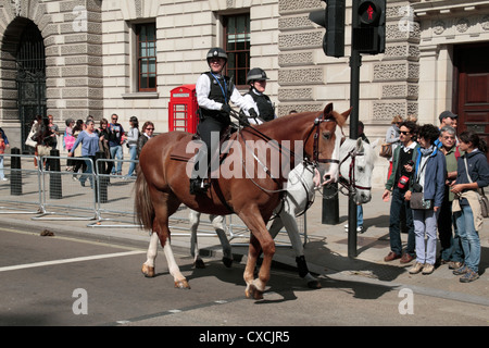 Metropolitan Polizistinnen auf dem Rücken der Pferde in der Nähe der Houses of Parliament, Westminster, London, UK. Stockfoto
