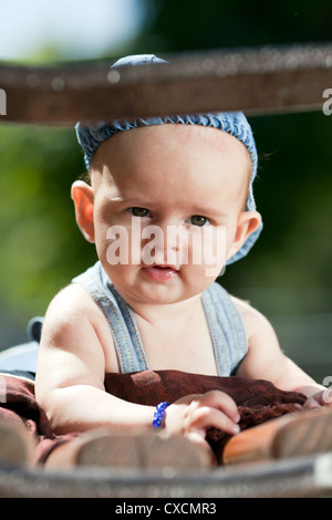 Sechste Reittiere alten Babyjungen Verlegung auf einer Holzbank Stockfoto