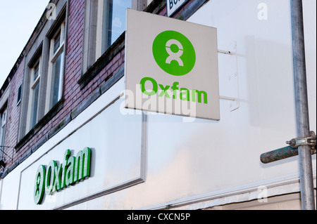 In der Nähe der Zeichen fest auf der Außenwand der Liebe Shop (Oxfam Name & berühmte Marke Logo in Lime Grün auf Weiß) - Otley, Yorkshire, England, UK. Stockfoto