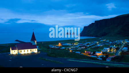 Luftaufnahme über Vik (Vik ich Myrdal) mit seiner Kirche und den Reynisdrangar (Basalt-Meer-Stacks) in der Morgendämmerung, Südisland Stockfoto