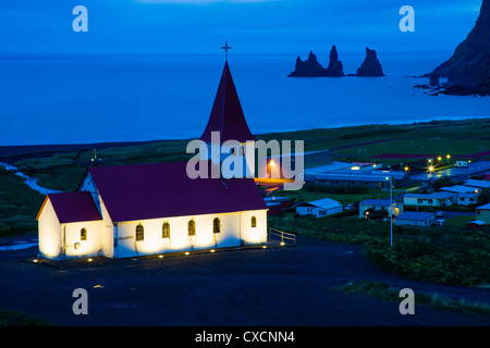 Luftaufnahme des Vik (Vik ich Myrdal) mit seiner Kirche und den Reynisdrangar (Basalt-Meer-Stacks) in der Morgendämmerung, Südisland Stockfoto