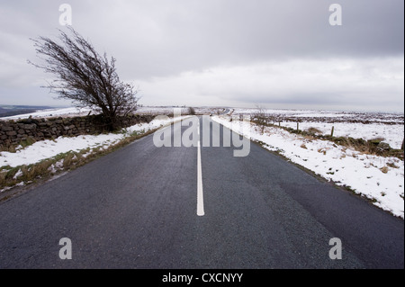 Den Blick von dem Zentrum des ruhigen gerader Strecke mit country lane über weiße moorland Hochland am Tag des kalten Winter schneiden - West Yorkshire, England, Großbritannien Stockfoto