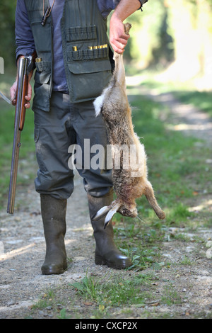 Jäger Holding Tote Kaninchen Stockfoto