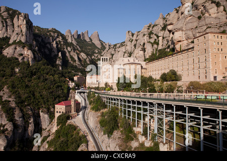 Vorderansicht des Montserrat mit Bergen im Hintergrund und über sowie das Gleis, das Besucher bringt. Stockfoto