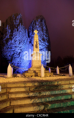 Es ist ein Foto von einem Kriegerdenkmal bei Nacht. Es ist in einem kleinen Dorf oder Normandie in der Landschaft von Frankreich. Es gibt blaues Licht Stockfoto