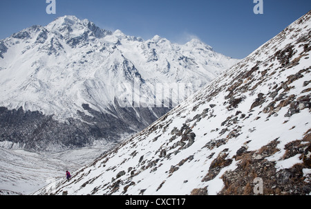 Frau im Schnee auf der steilen Seite eines Berges, Langtang-Tal, Nepal trekking Stockfoto