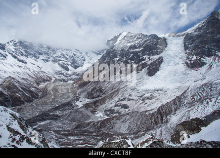 Schneebedeckte Berge und eine gefrorene Gletscher hinter dem Dorf Kyanjin Gompa, Langtang-Tal, Nepal Stockfoto