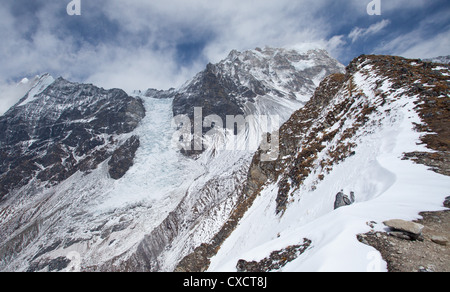 Schneebedeckte Berge und eine gefrorene Gletscher hinter dem Dorf Kyanjin Gompa, Langtang-Tal, Nepal Stockfoto