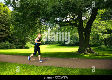 Gesunde junge Sportler im Park laufen Stockfoto