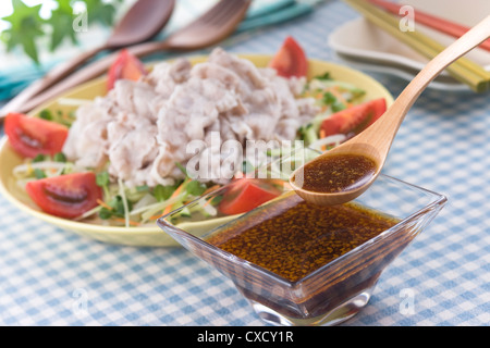 Scooping chinesische Salat-Dressing mit Löffel Stockfoto