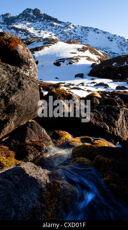 Alpine Stream und felsige Landschaft schneebedeckt im Gosaikunda, hoch gelegenen Haltestelle für Trekker, Nepal Stockfoto