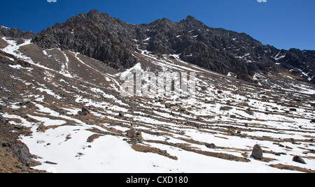 Aussicht auf ein Bergtal im Schnee und umgeben von Bergen, Abfahrt vom Pass Laurebina La, Nepal Stockfoto