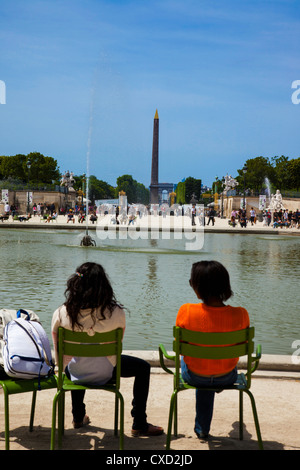 Zwei Touristen entspannen neben einem Wasser verfügen im Jardin des Tulleries Blick in Richtung Place De La Concorde in Paris Frankreich Stockfoto