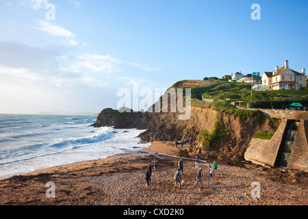 Touristen spielen im Abendlicht auf Shippen Strand Volleyball, am äußeren Hoffnung, Hoffnung Cove, South Hams, Devon, England, UK Stockfoto