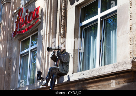 Eine Figur als Fotograf mit einer Kamera und einem großen Objektiv Stockfoto