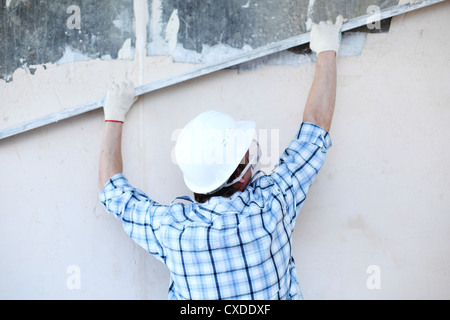 Arbeiter richtet Wand für die Leitung Stockfoto