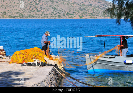 Zwei kretische Fischer, die Fischernetze für das abendliche Fischen in ihren Kaiques, Elounda, Kreta, vorbereiten Stockfoto