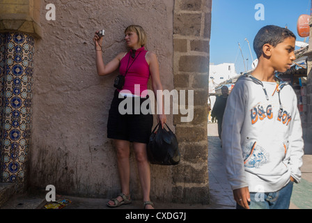 Eine touristische Frau in Essaouira fotografieren mit einer digitalen Kompaktkamera mit jungen Schüler Stockfoto