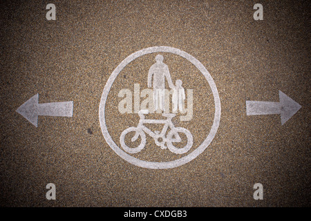 Gemalte Zeichen auf Asphalt für Fußgänger und engagierten Fahrradweg. Stockfoto