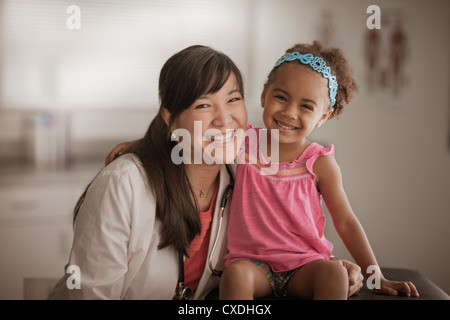 Arzt und Mädchen lächelnd in Arztpraxis Stockfoto