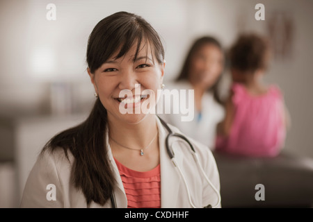 Lächelnde chinesische Arzt in Arztpraxis Stockfoto