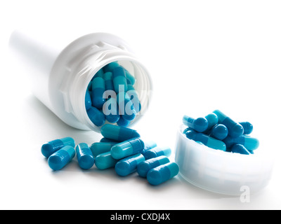 Kunststoff-Behälter mit blauen Gel-Kapseln auf weißem Hintergrund. Stockfoto
